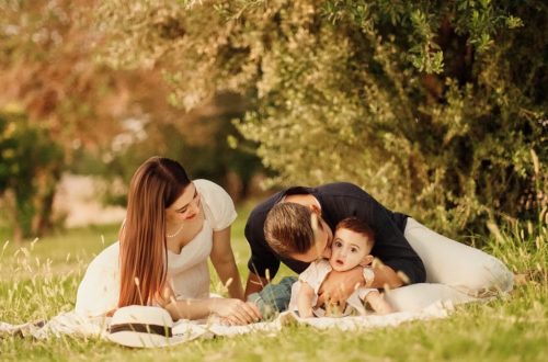 A happy family having a picnic in a lush green park setting during the day.