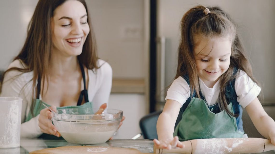 A joyful moment as a mother and daughter bond while baking pastries at home.
