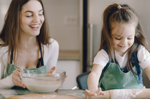 A joyful moment as a mother and daughter bond while baking pastries at home.