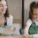 A joyful moment as a mother and daughter bond while baking pastries at home.